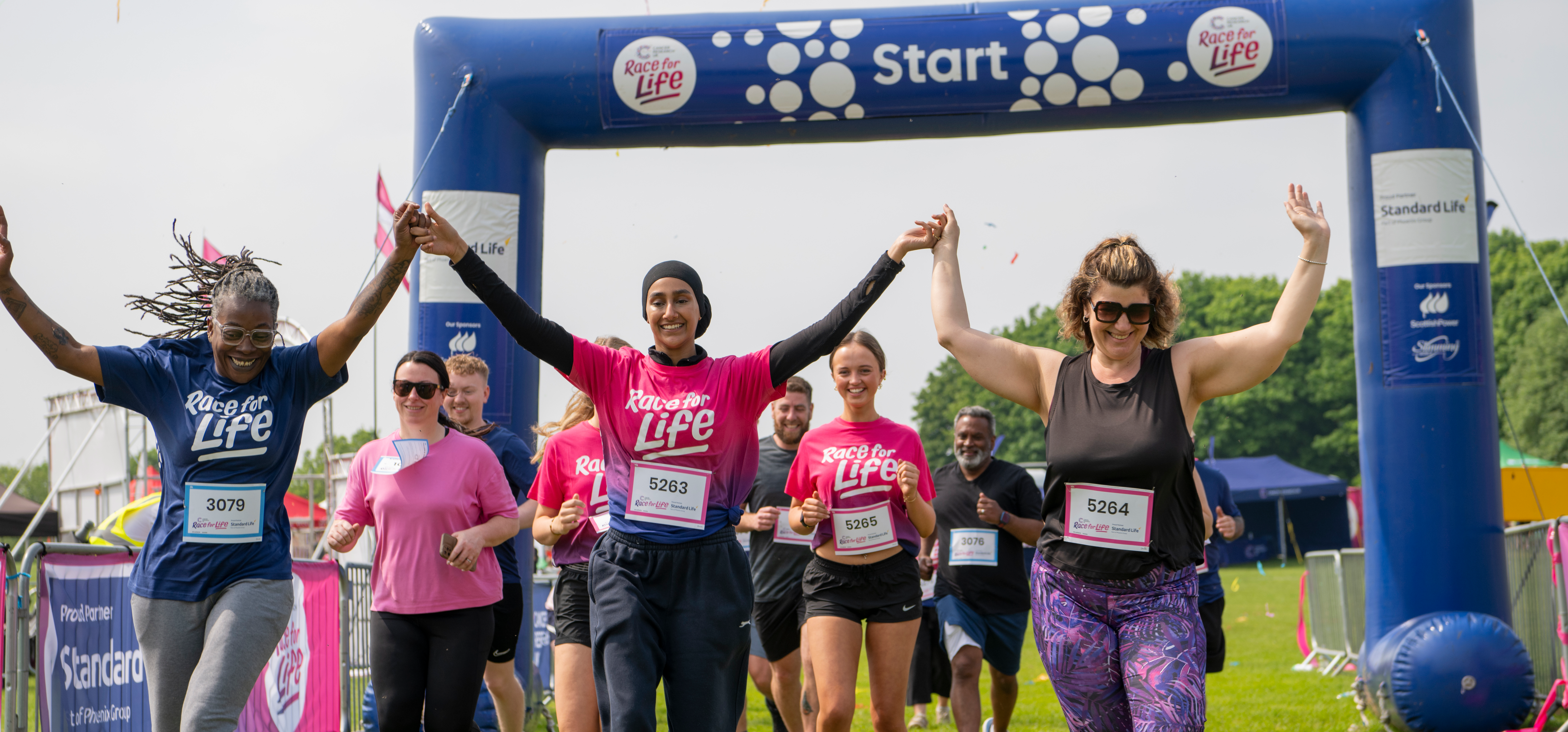 People running through the finish line in an event with streamers 